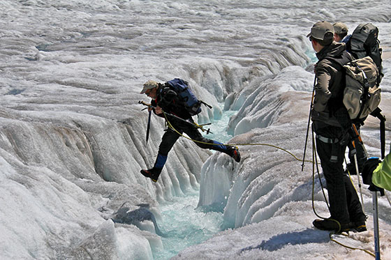 Werner Fischer jumping across the stream 
 Jumping is the way to cross it 
 like we did it for several crevasses